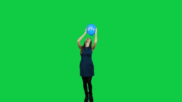 Girl playing with the balloon in front of a green screen