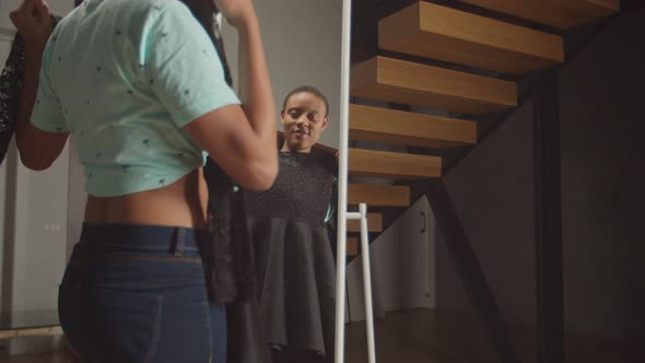 Positive Woman Choosing Dress in Front of Mirror