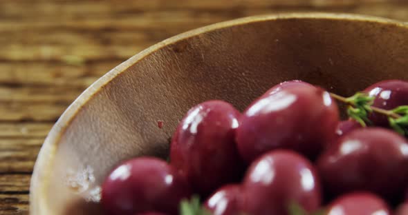 Fresh red olives and rosemary in a bowl