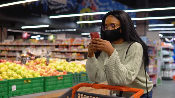 Girl in a Mask Talking on the Phone in the Supermarket