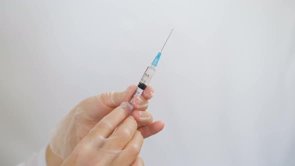 The doctor holds in his hands a medical syringe with medicine before an injection