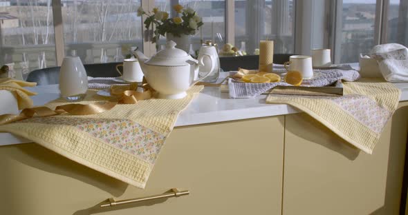 A Long Kitchen Table with a White Marble Top Stands in a Kitchen Filled with Soft Daylight