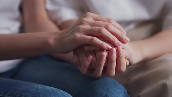  Close-up shot of two people holding hands for encouragement