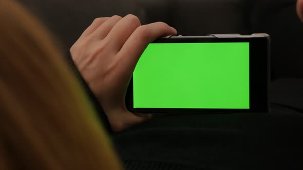 Female on smartphone with green screen display scrolling pages  4K 2160p UltaHD footage - Green scre