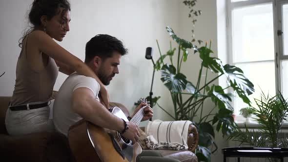 Male Guitar Player with His Woman Wife Girlfriend at Home in Living Room Spbd