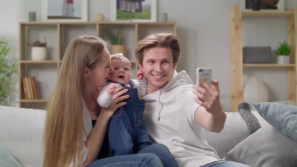 Young Family Taking a Selfie on the Sofa in the Living Room