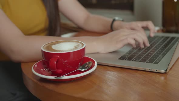 Woman Using Laptop With A Cup Of Coffee