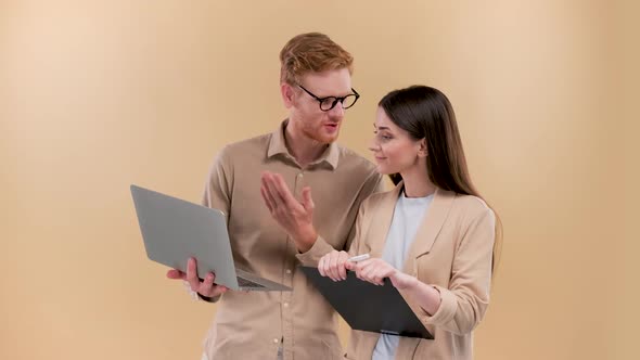 Young Business Colleagues Working and Brainstorming with Laptop Over a Beige Background