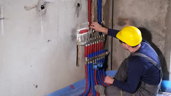 A Male Plumber Checks the Water Supply Pipes in the House Worker Hands Fixing Heating System