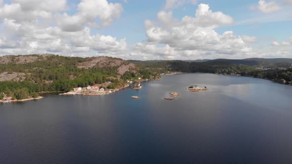 Aerial pan of bay with rocky islands, beautiful summer sky with clouds