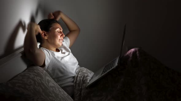 Girl Before Going to Bed Looks at Her Laptop
