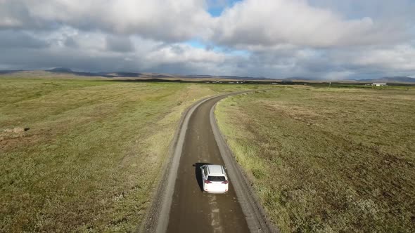 Driving white SUV through beautiful countryside in Iceland - drone footage