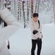 a Photographer Girl Takes Pictures of a Guy in a Winter Forest - VideoHive Item for Sale