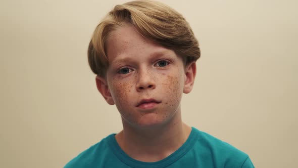 A close-up view of a handsome little boy is looking to the camera