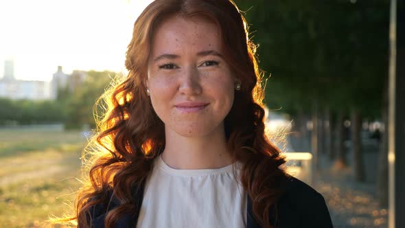 Happy Woman with Long Curly Hair Shows Thumbup in Park