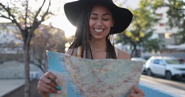 Bohemian mixed race young woman looking on city map - Summer vacation, travel and lifestyle concept