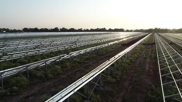 Beautiful Aerial Footage of a Field with Rows of Solar Panel Racks Construction