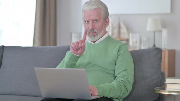 Old Man with Laptop Showing No Sign with Finger