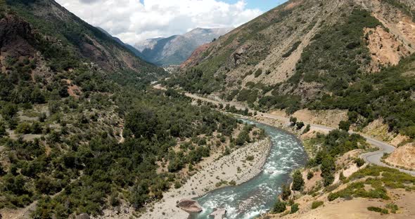 Aerial view of a pan of the Maule river in the central zone with arid mountains in Chile on a sunny