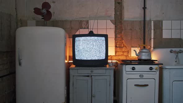 Old Flickering CRT TV with Antenna Stands on the Locker and Shows Interference