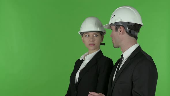 Front View of Female Construction Engineer Pointing Up Standing with Male Engineer, Chroma Key