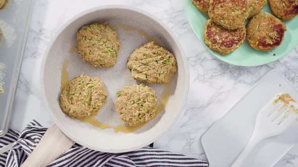 Flat lay. Step by step. Frying zucchini cakes in olive oil on a small frying pan.