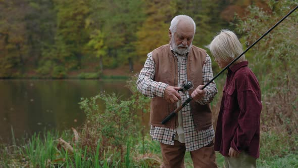 Grandfather Showing His Grandson How to Use Fishing Rod