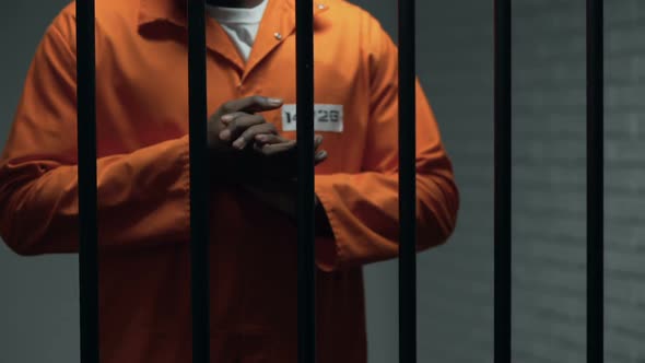 Anxious African-American Prisoner Rubbing Hands, Waiting Sentence, Punishment