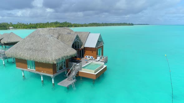 Aerial drone view of a luxury resort and overwater bungalows in Bora Bora tropical island