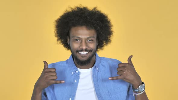 AfroAmerican Man Gesturing Thumbs Up on Yellow Background