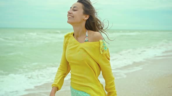 Portrait Happy Expression Woman with Blowing Hair Wearing Yellow Shirt Having Fun on Beach and