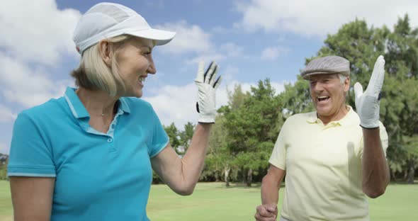 Two happy golfers giving high five