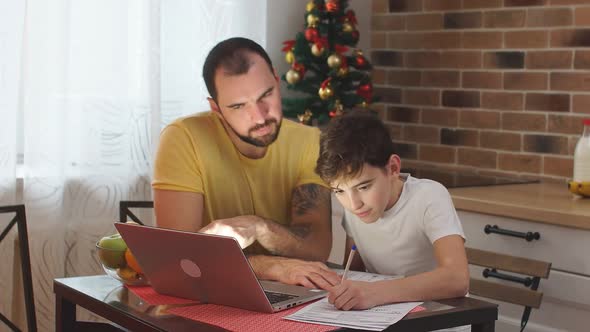 Young Father Helper and Studying Kid Boy at Home