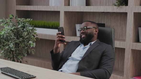 Happy African American Businessman Using Phone Mobile at Workplace Texting Sms Smiling Man Looking