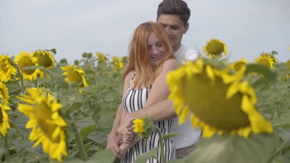 Beautiful Happy Couple Hugging on the Sunflower Field