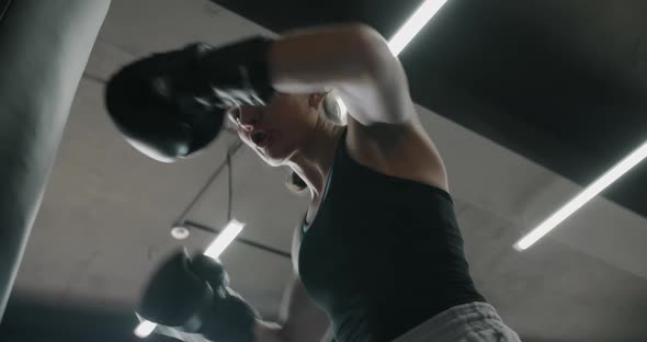 Woman Kickboxer in Boxing Gloves Punches Boxer Bag in Slow Motion Training in Boxing Club 60p Prores