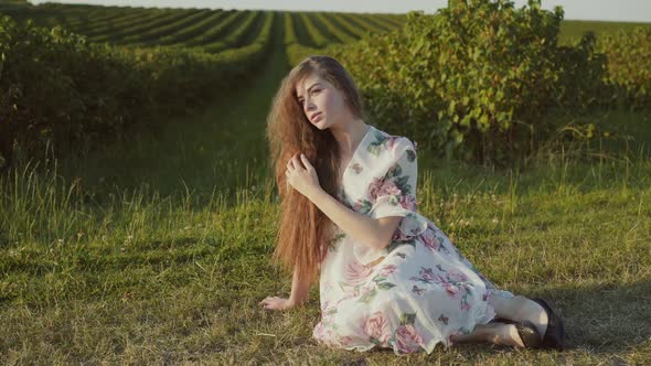 Beautiful Portrait of Young Lady with Long Hair and Wore in Dress Sits in Pose