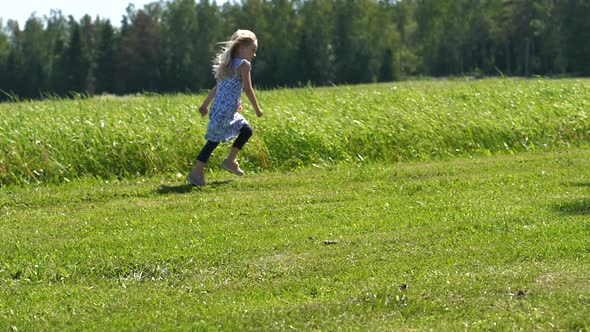 Happy summer girl running in green grass landscape, freedom concept