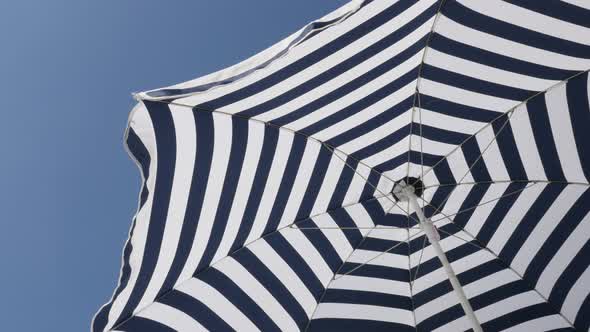 Striped  umbrella sun protection fabric moving on the wind 4K 2160p 30fps UltraHD footage - Blue and