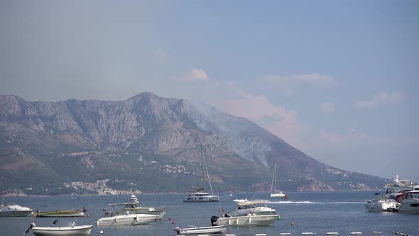 Yachts Stand in the Sea Against the Background of Burning Mountains in Budva