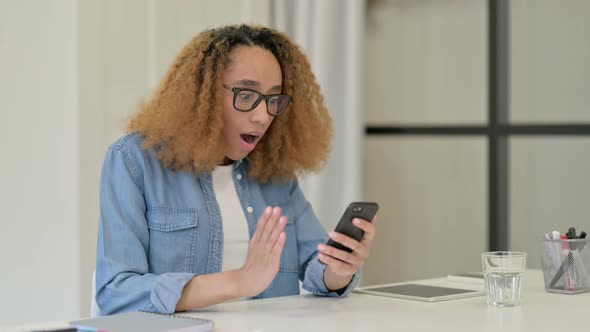 Successful African Woman Celebrating on Smartphone