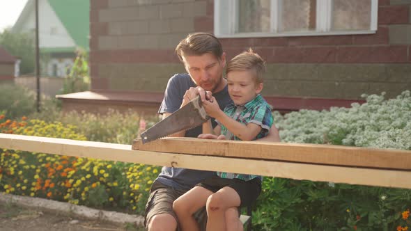 Male Carpenter with His Son Working Outside Near the House