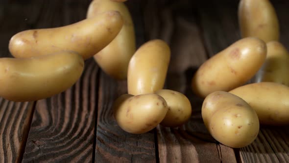 Super Slow Motion Shot of Potatoes Rolling on Old Wooden Table at 1000Fps