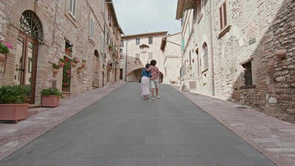 Romantic Couple Walking Visiting Rural Town of Assisi.Back follow.Friends Italian Trip in Umbria