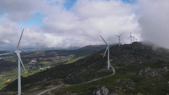 Wind turbine generators on top of hill and surrounding landscape, Caramulo in Portugal. Aerial forwa