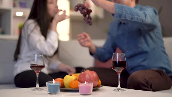 Couple drinking wine and eating fruit.