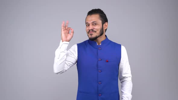 Happy Indian man showing an okay sign to the camera in an Indian outfit
