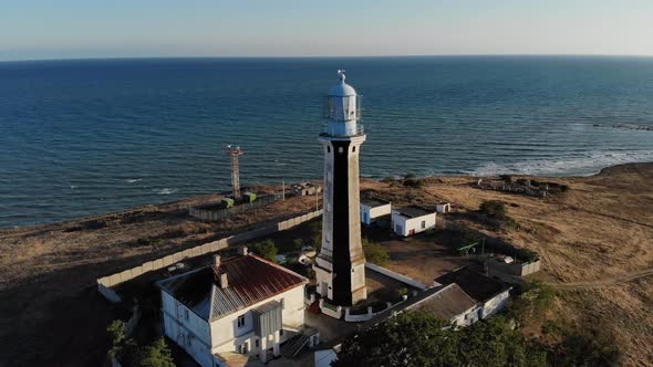 Aerial View of an Unknown Lighthouse with Black and White Edges on the Peninsula's Promontory