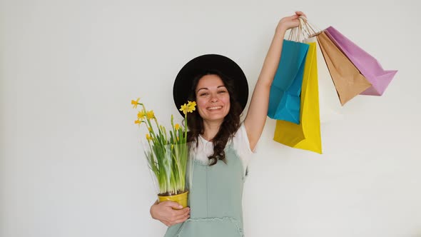 The Girl Happily Makes Purchases with Packages and Flowers