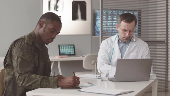Military Officer Signing Medical Document at Doctors Office